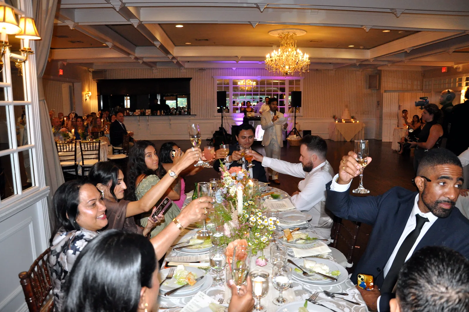 Wedding guests raising a toast at the head table