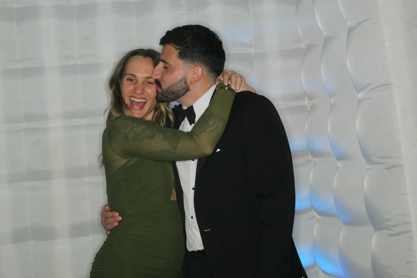 Couple sharing a kiss in the wedding photo booth